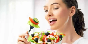 uma mulher comendo uma salada possivelmente preocupada com os transtornos alimentares